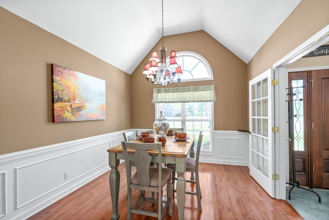 dining space with vaulted ceiling, light hardwood / wood-style flooring, and a notable chandelier