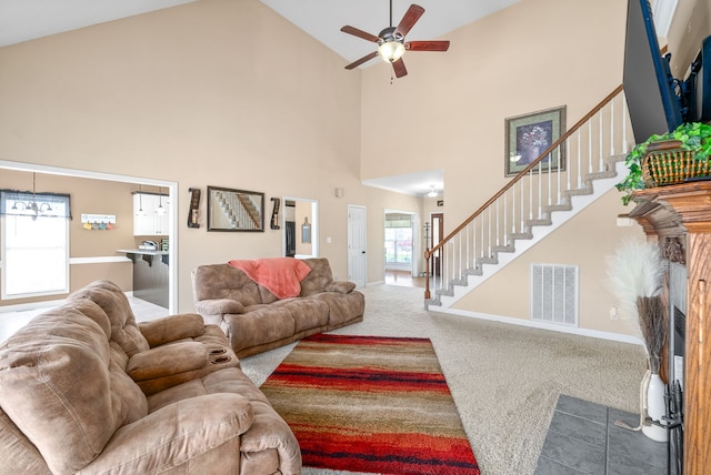 carpeted living room with ceiling fan and high vaulted ceiling