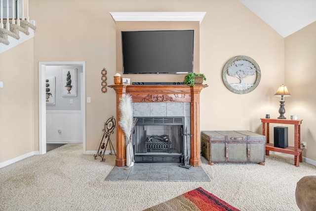 living room featuring a tiled fireplace, vaulted ceiling, and carpet flooring