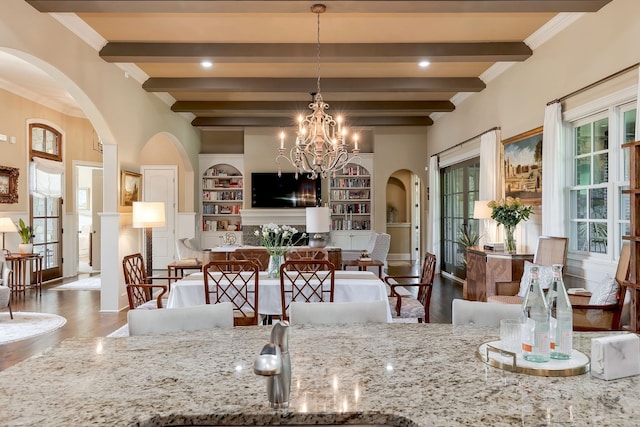 kitchen with light stone countertops, decorative light fixtures, dark hardwood / wood-style floors, and a wealth of natural light