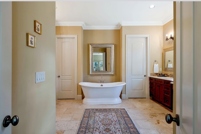 bathroom featuring crown molding, vanity, and a bathing tub