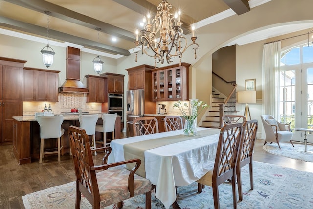 dining area featuring beamed ceiling, ornamental molding, dark wood-type flooring, and a chandelier