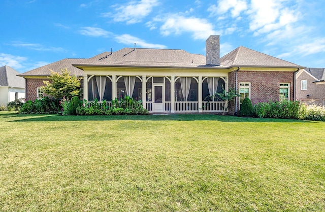 back of property with a sunroom and a yard