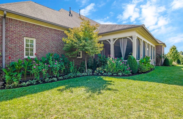 view of home's exterior featuring a yard and a sunroom