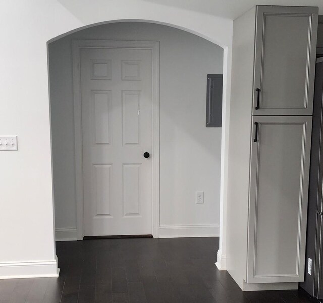 corridor featuring electric panel and dark hardwood / wood-style flooring