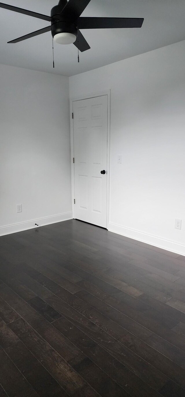 unfurnished room featuring ceiling fan and dark wood-type flooring