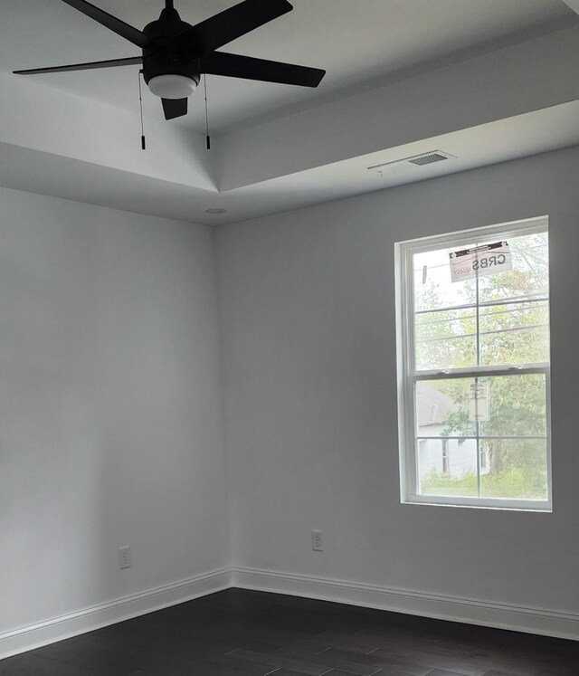 empty room with ceiling fan and dark hardwood / wood-style floors