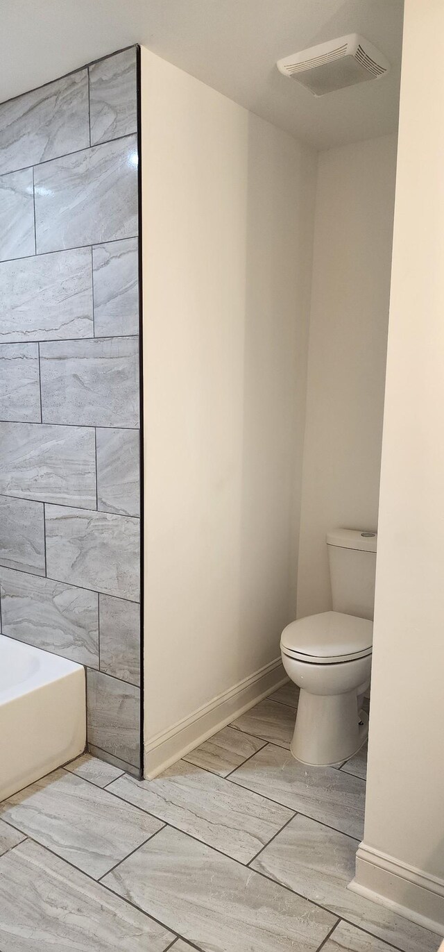 bathroom featuring toilet and a bath