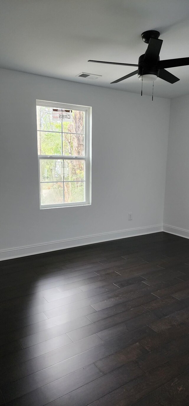 empty room featuring ceiling fan and dark hardwood / wood-style flooring