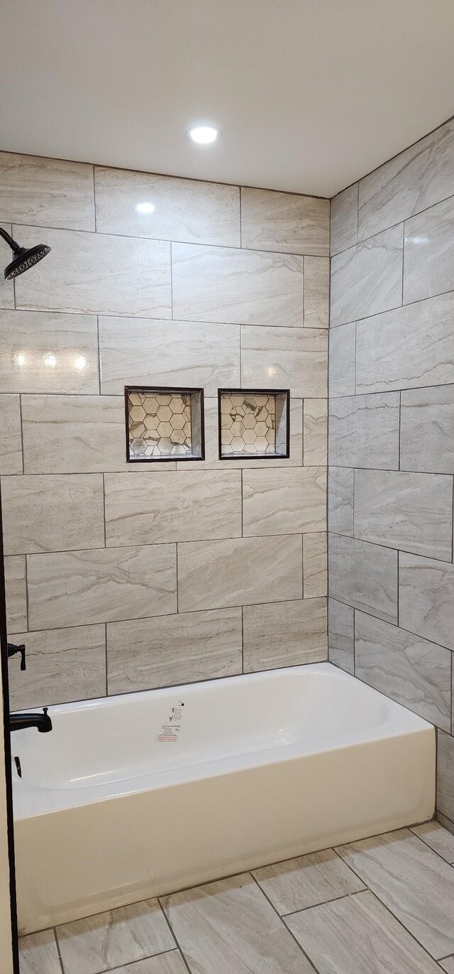 bathroom with tile walls and tiled shower / bath combo