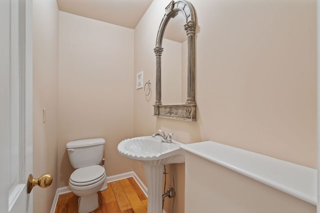 bathroom featuring wood-type flooring and toilet