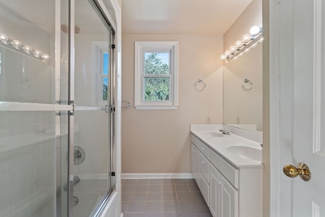 bathroom with combined bath / shower with glass door, vanity, and tile patterned flooring