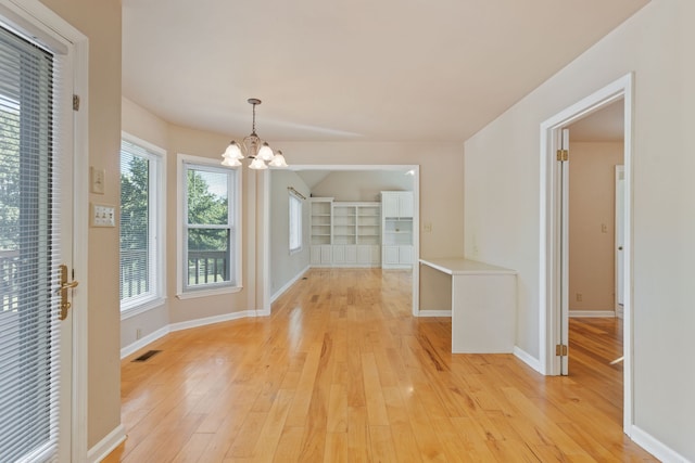 unfurnished dining area with light hardwood / wood-style floors and an inviting chandelier