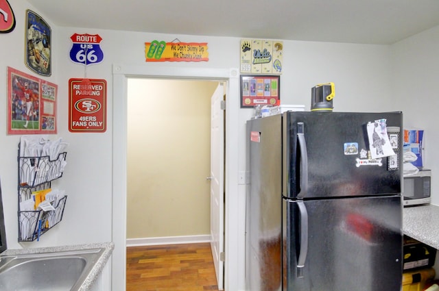 kitchen featuring hardwood / wood-style floors and fridge