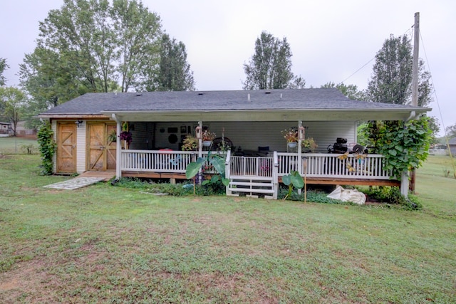 rear view of house with a lawn and an outdoor structure