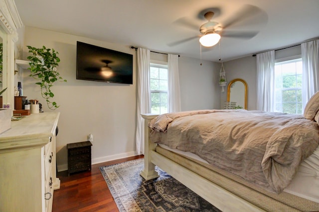 bedroom featuring multiple windows, dark hardwood / wood-style floors, and ceiling fan