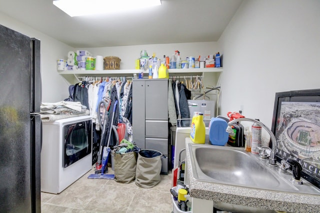 clothes washing area featuring sink, light tile patterned floors, and washer / dryer