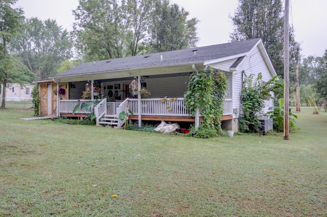 rear view of property featuring a lawn and central air condition unit