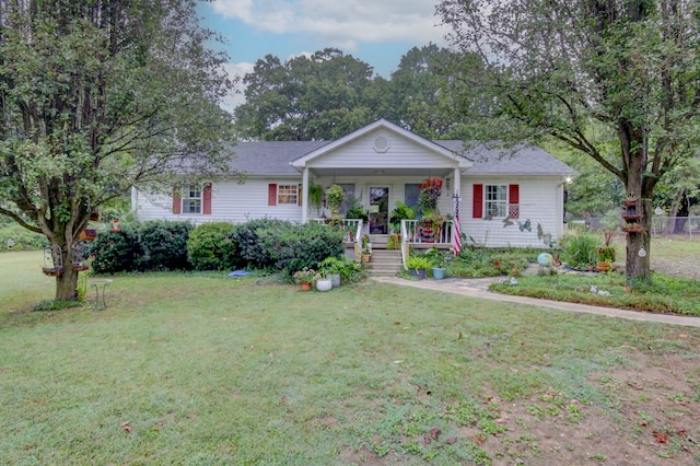 ranch-style home featuring covered porch and a front lawn