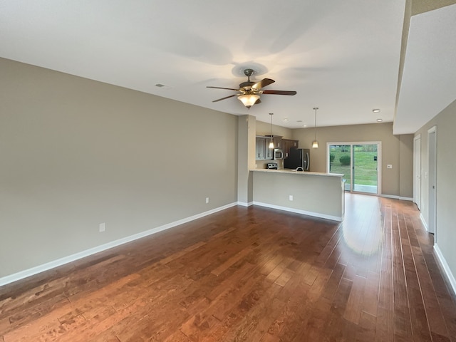 unfurnished living room featuring ceiling fan and dark hardwood / wood-style floors