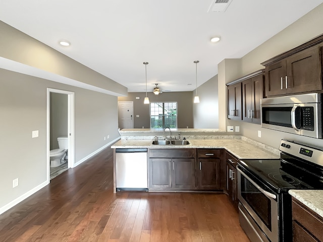 kitchen with sink, appliances with stainless steel finishes, hanging light fixtures, and kitchen peninsula