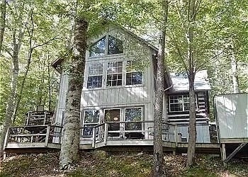 rear view of house featuring a wooden deck