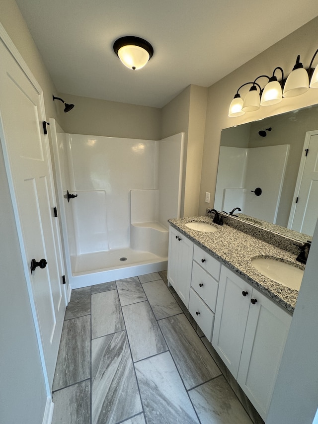 bathroom featuring walk in shower and vanity