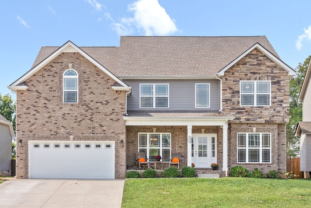 view of front of house featuring a front yard, a garage, and a porch