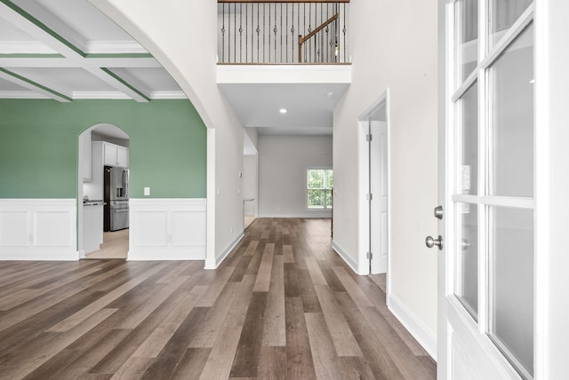 entryway featuring crown molding, beam ceiling, coffered ceiling, and hardwood / wood-style floors