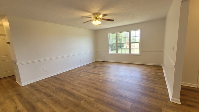 spare room featuring ceiling fan, a textured ceiling, and dark wood-type flooring