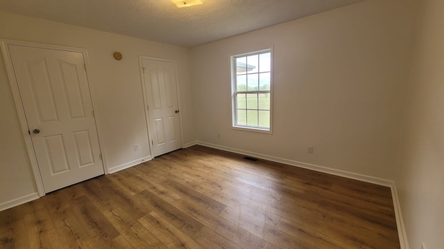 unfurnished bedroom featuring wood-type flooring and a textured ceiling