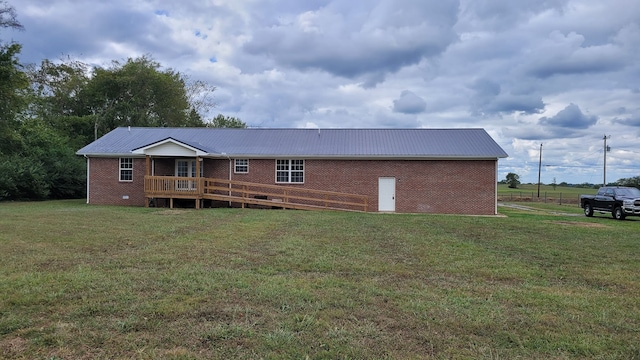 rear view of property featuring a deck and a lawn