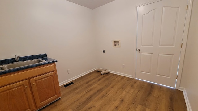 laundry area featuring washer hookup, light hardwood / wood-style flooring, sink, and hookup for an electric dryer