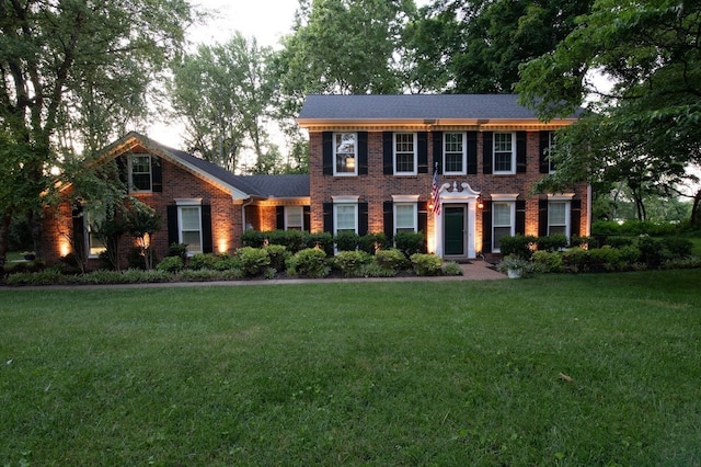 colonial-style house featuring a front yard