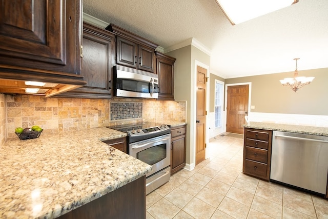 kitchen featuring dark brown cabinetry, light tile patterned flooring, hanging light fixtures, backsplash, and appliances with stainless steel finishes