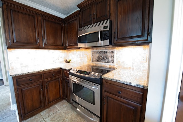 kitchen with light stone countertops, a textured ceiling, appliances with stainless steel finishes, and light tile patterned flooring