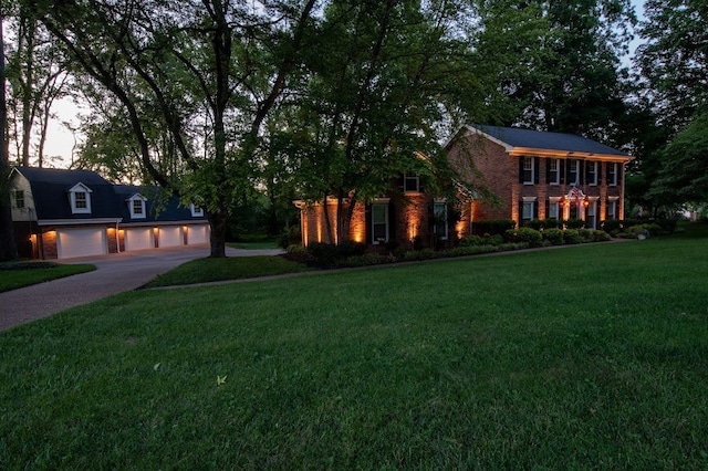 colonial inspired home with a yard and a garage