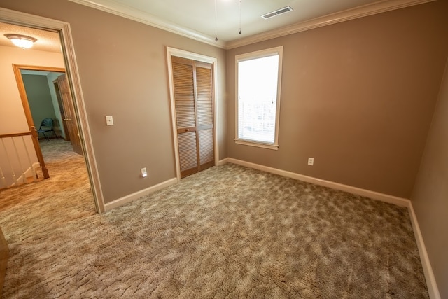 unfurnished bedroom featuring ornamental molding, light colored carpet, and a closet