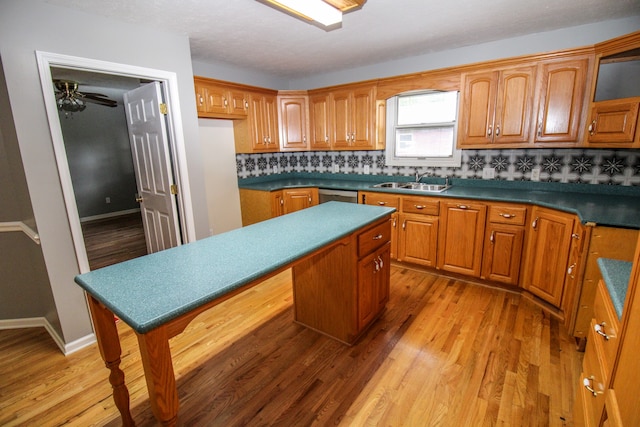 kitchen featuring light hardwood / wood-style floors, sink, decorative backsplash, ceiling fan, and stainless steel dishwasher