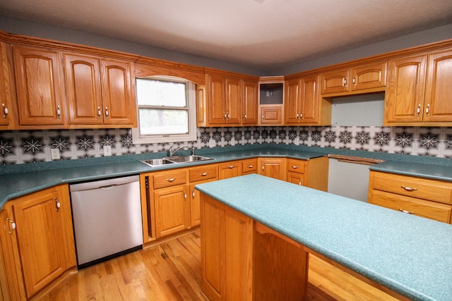 kitchen with decorative backsplash, dishwasher, light hardwood / wood-style flooring, stainless steel dishwasher, and sink