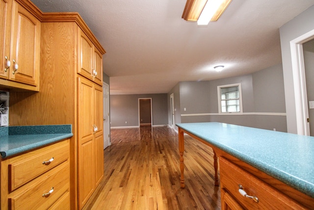 kitchen with a textured ceiling and light hardwood / wood-style flooring