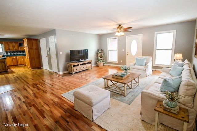 living room featuring light wood-type flooring and ceiling fan