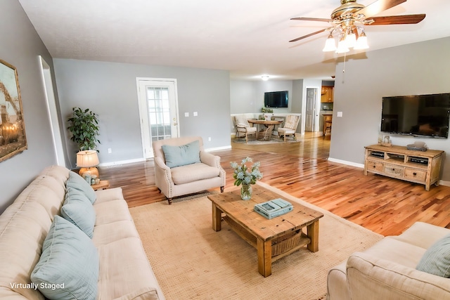 living room with ceiling fan and light hardwood / wood-style flooring