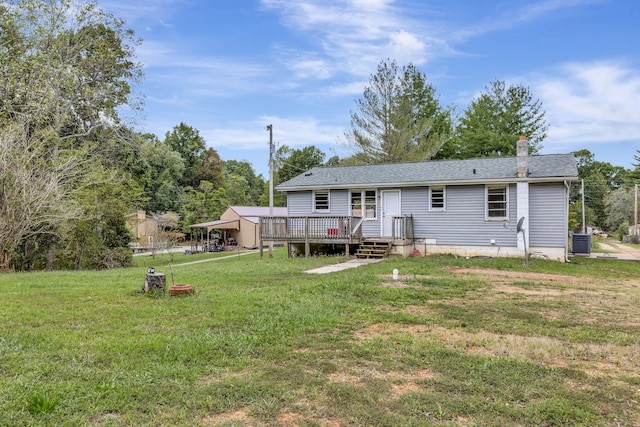 rear view of house featuring a lawn, a wooden deck, and central AC