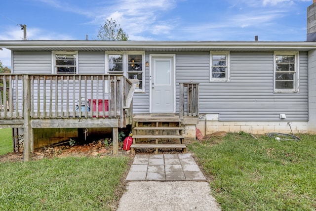 view of front of home featuring a front yard and a wooden deck