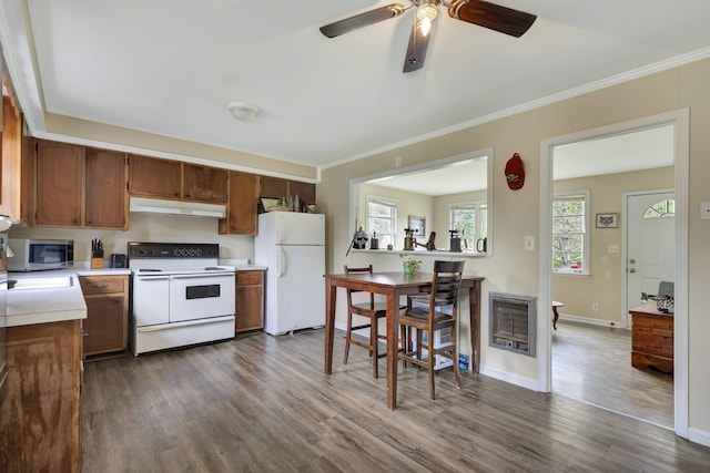 kitchen featuring white appliances, hardwood / wood-style flooring, heating unit, and crown molding