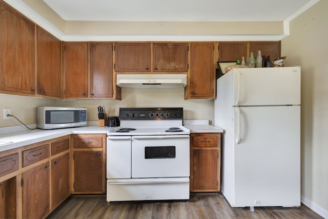 kitchen with white appliances, crown molding, and dark wood-type flooring