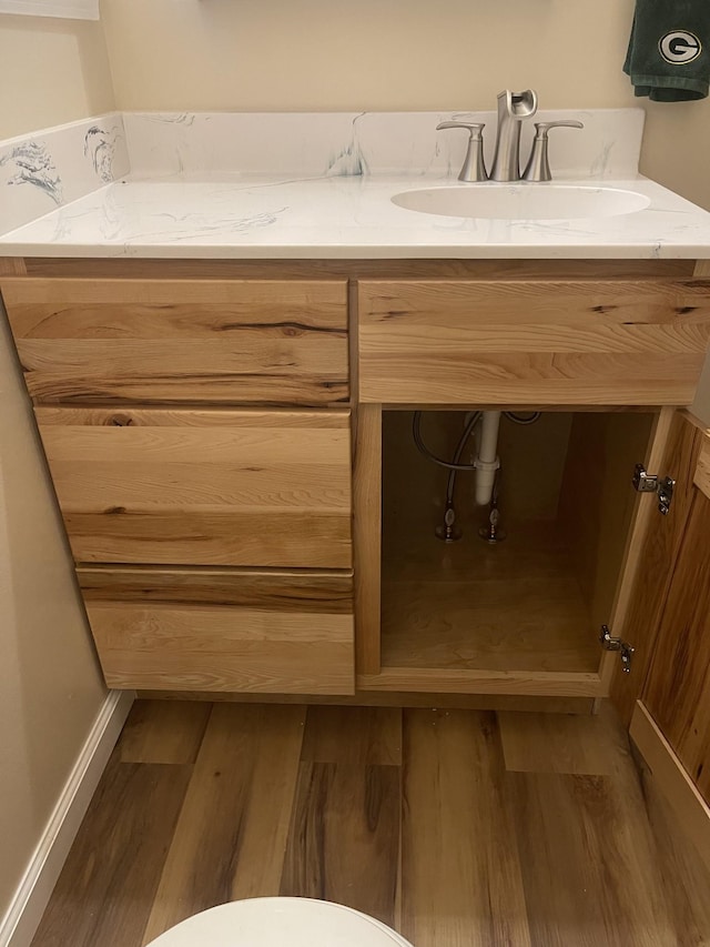 bathroom featuring toilet, vanity, and hardwood / wood-style flooring