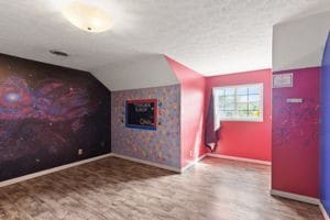 additional living space with hardwood / wood-style flooring and lofted ceiling