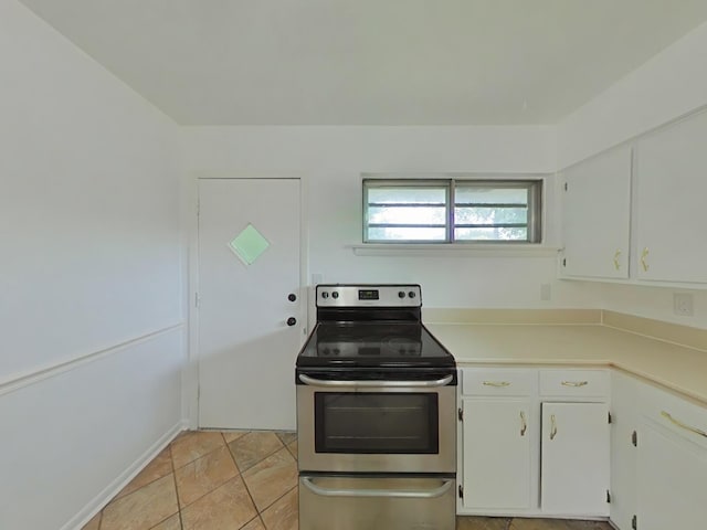 kitchen featuring white cabinets, stainless steel electric stove, and light tile patterned floors